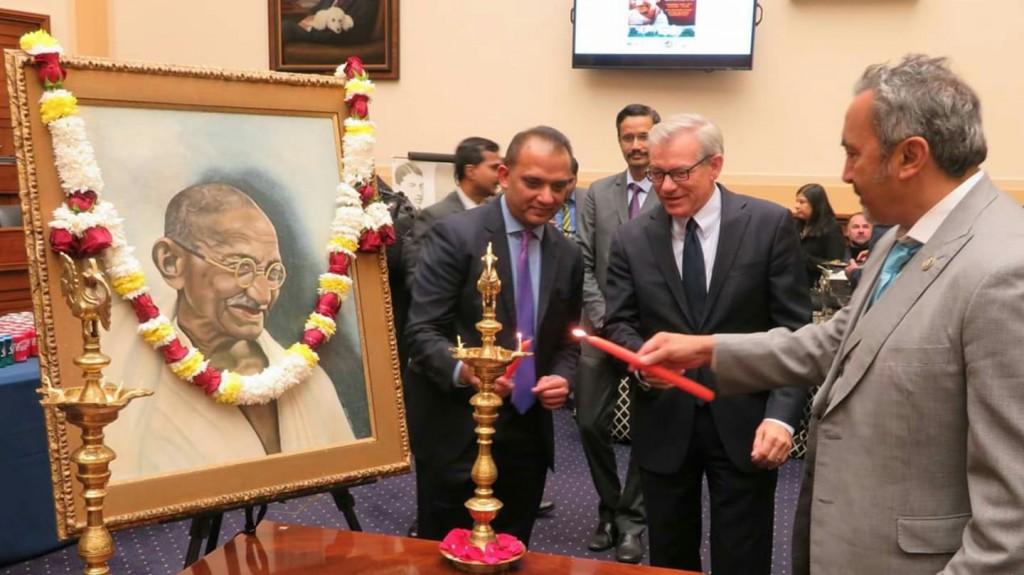 Congressman Ami Bera (right) lights the 'diya' (ceremonial lamp) at the launch event on Capitol Hill for the year-long celebrations of the 150th birth anniversary of Mahatma Gandhi. Seen in the center is Republican lawmaker David Schweikert of Arizona
