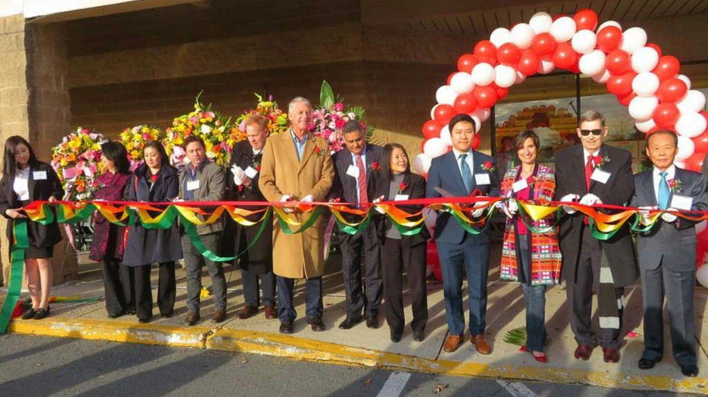 At the ribbon-cutting ceremony of the new H Mart grocery store in Herndon, Virginia, are seen: H Mart President Brian Kwon (fourth from right); Virginia Delegate Jennifer Boysko (third from right); and Herndon Council member Richard Kaufman (second from right)