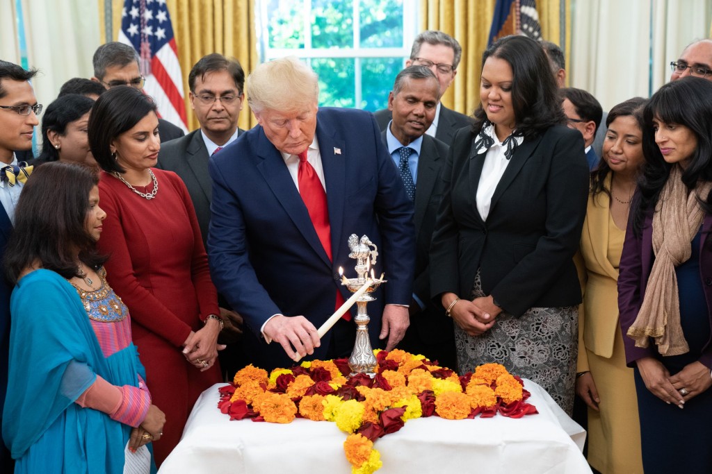 President Donald Trump lighting the Diwali 'diya' in the Oval Office, surrounded primarily by Indian-Americans serving in his administration. It is the third consecutive year that the president has celebrated the popular Indian festival of lights in the White House. Official White House Photo by Shealah Craighead
